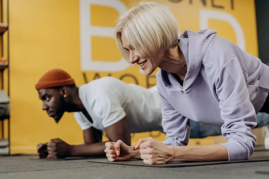 Starting Exercise at 40: 7 Essential Tips To Revolutionize Your Life 2 starting exercise at 40 with a very fit couple doing planks in a gym