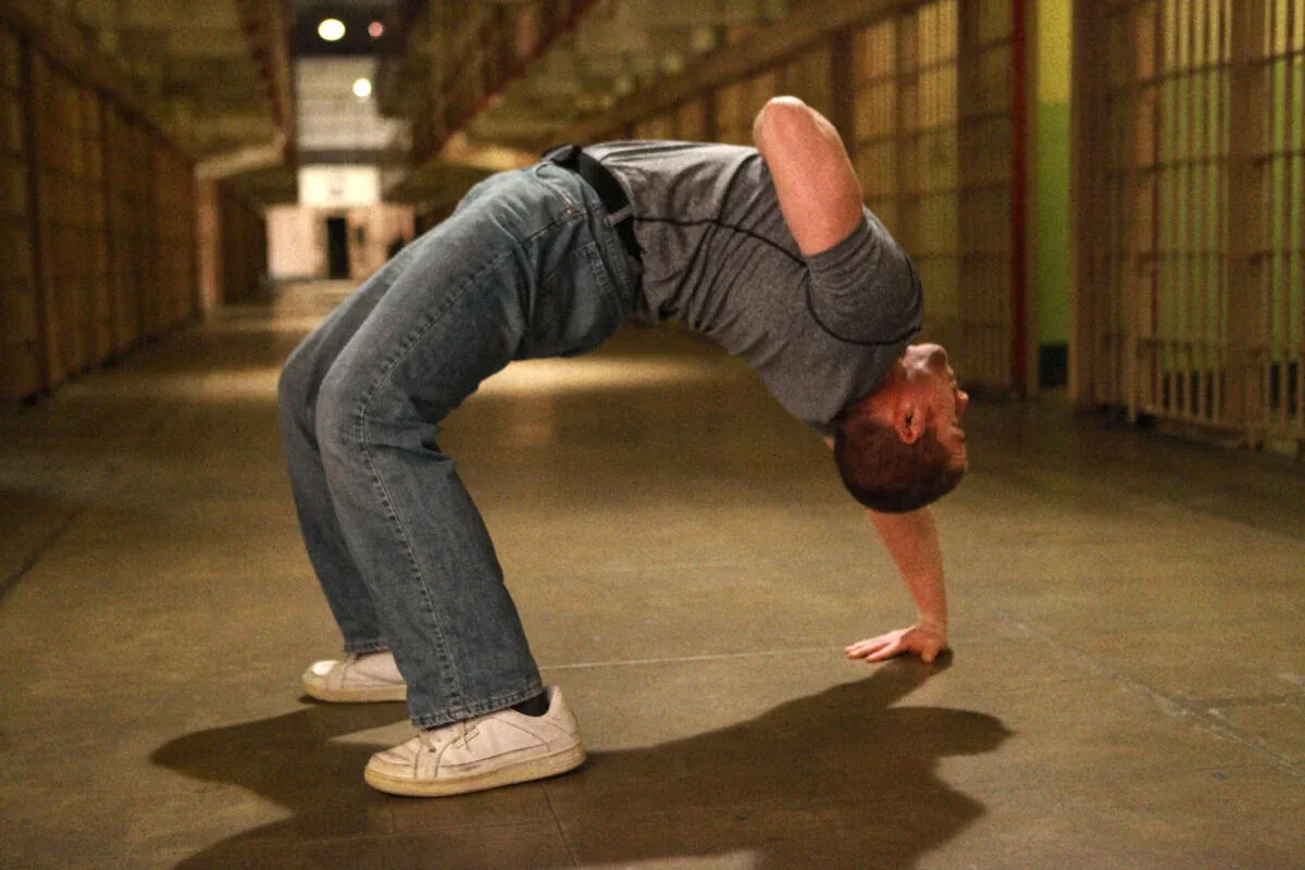 Convict Conditioning Review: A Journey Back to Strength 7 man doing a one arm full body bridge