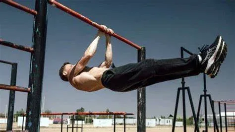 Can Calisthenics Build Muscle and Get Rid of Fat? 7 Key Aspects for Maximum Results. 3 man doing a back lever on a bar demonstrating building muscle with calisthenics.