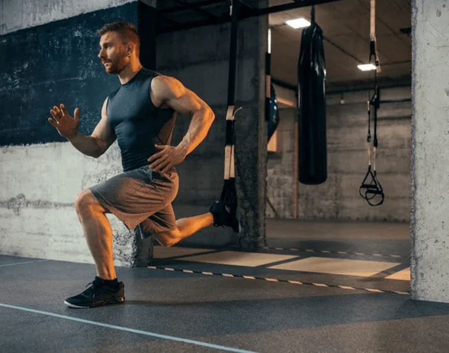 Unlock Calisthenics Strength: 3 Calisthenics Routines 9 man doing a Bulgarian split squat in a gym setting