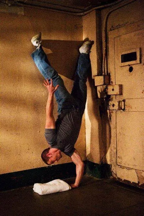 Convict Conditioning Review: A Journey Back to Strength 6 man doing one arm handstand