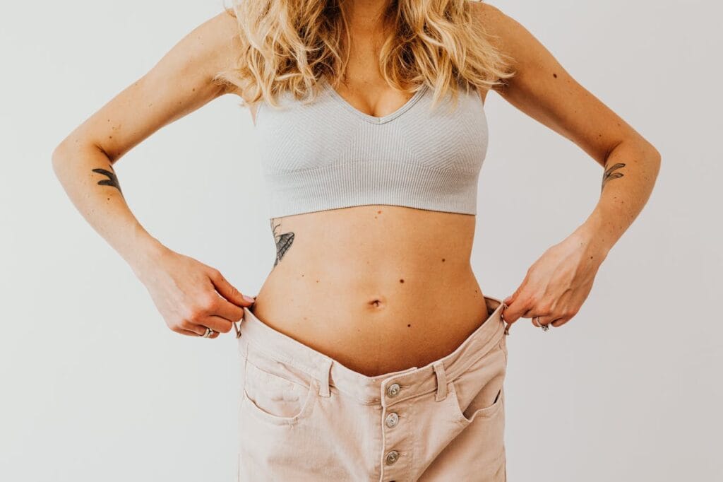 Lose Fat: Transform Your Body in 30 Days! 4 woman showing her fat lost progress wearing the larger pants she started out with