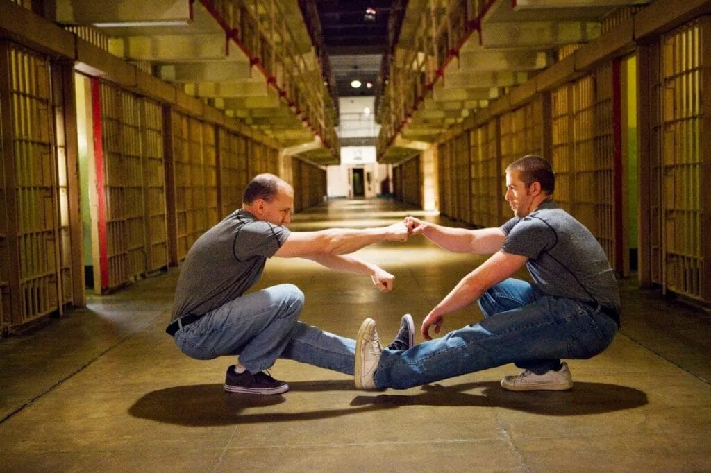 two men doing pistol squats