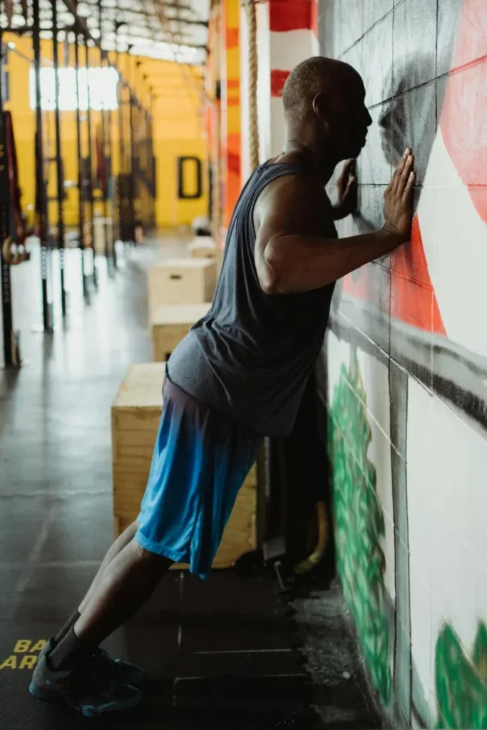 Calisthenics for Seniors: 7 Powerful Exercises to Boost Strength and Vitality 4 fit older man doing wall pushups in a gym