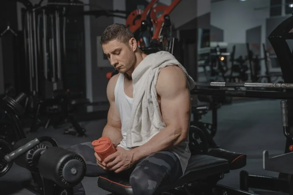 10 Incredible Protein Supplements for Strength Training: Maximize Your Gains 3 man on workout bench with shaker bottle