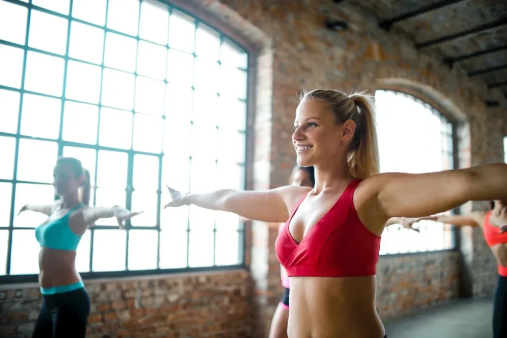 Calisthenics for Seniors: 7 Powerful Exercises to Boost Strength and Vitality 8 women doing arm circles in a gym with a group