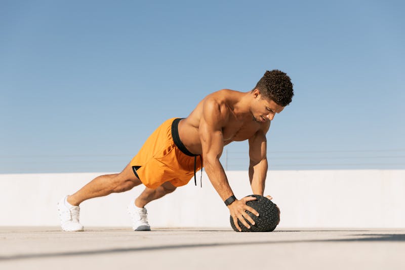 Transform Your Fitness: Quick 15-Minute Home Workouts for Busy People 7 man performing pushups with medicine ball