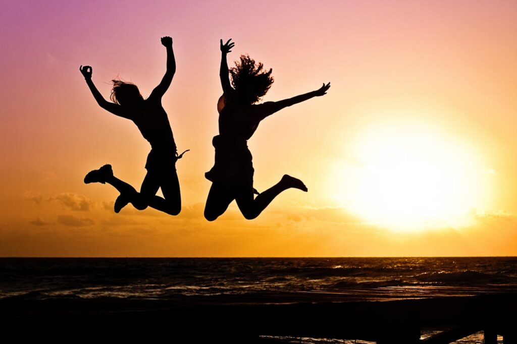 Beginner Calisthenics: 5 Powerful Moves to Build Strength Fast! 7 two people jumping with jubilance at sunset on a beach