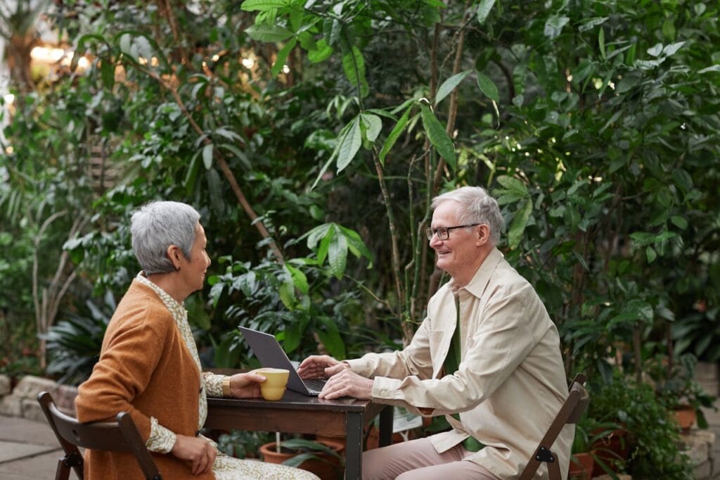 5 Easy Steps to Boost Senior Health and Wellness 7 a couple of happy seniors sitting and talking at a table outside.