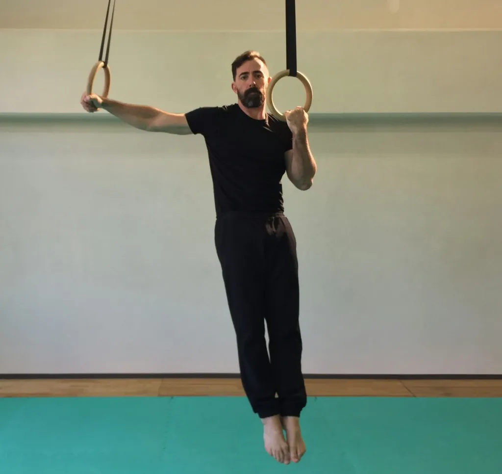 man doing archer pushups on rings