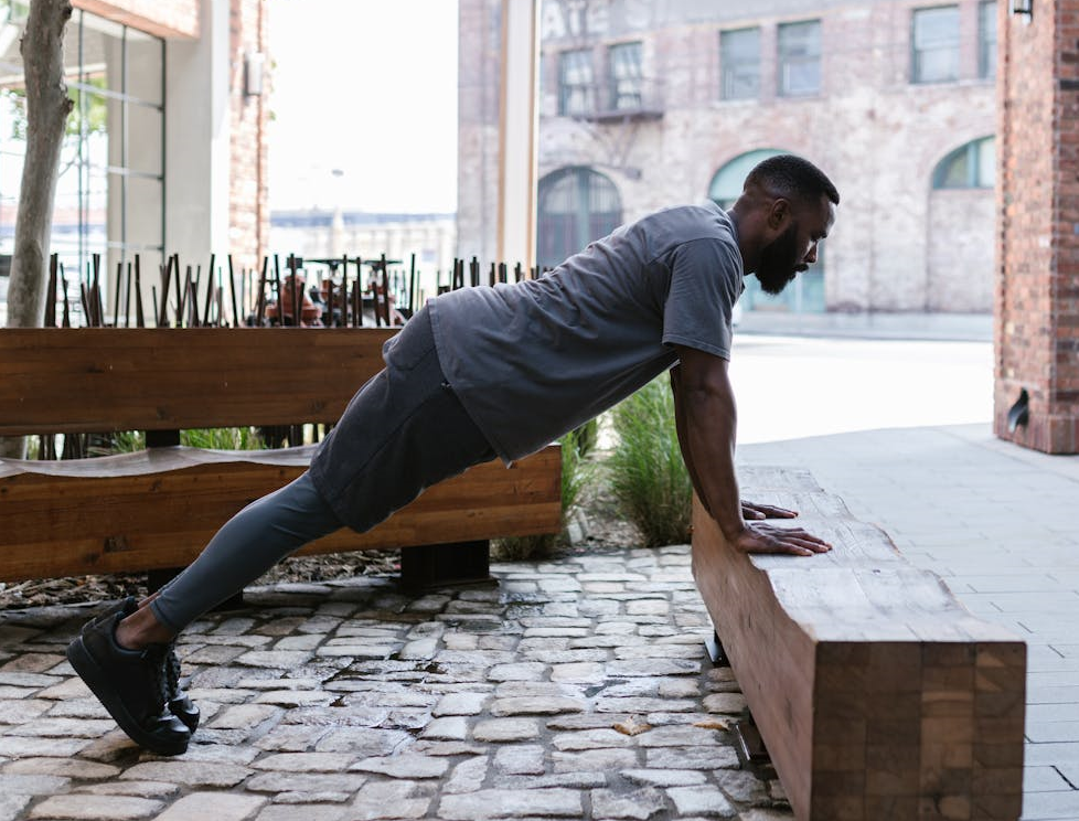 How to Master Different Push Ups: 7 Progressions for Strength and Fitness 3 different push ups - man doing incline pushups against a bench