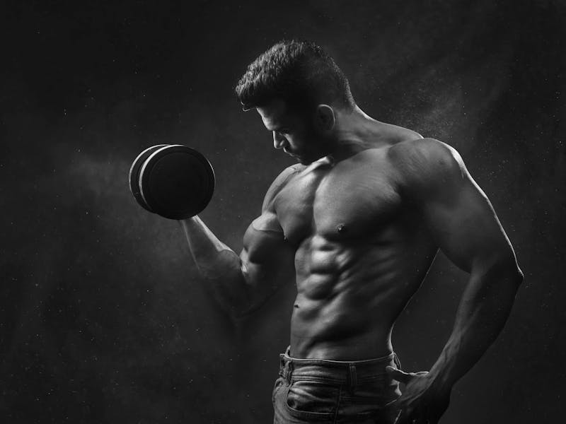 Portion Perfection: How a Digital Food Scale Can Simplify Your Health Journey 4 fit man doing dumbbell curls in darkened gym