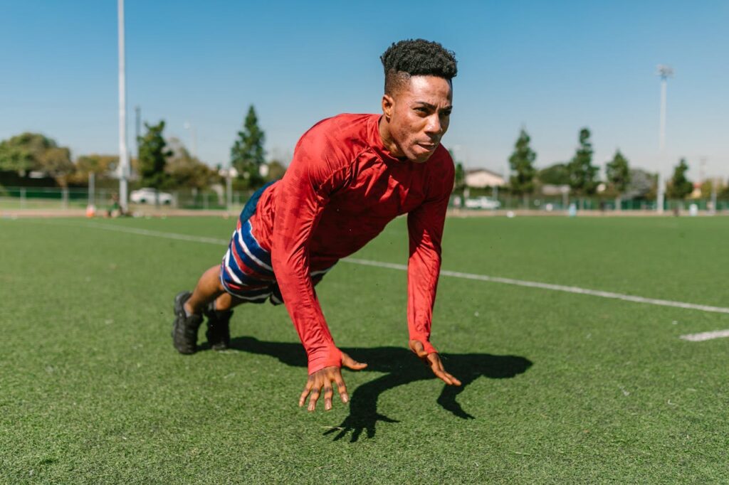 How to Master Different Push Ups: 7 Progressions for Strength and Fitness 7 man in open athletic field performing plyometric pushups
