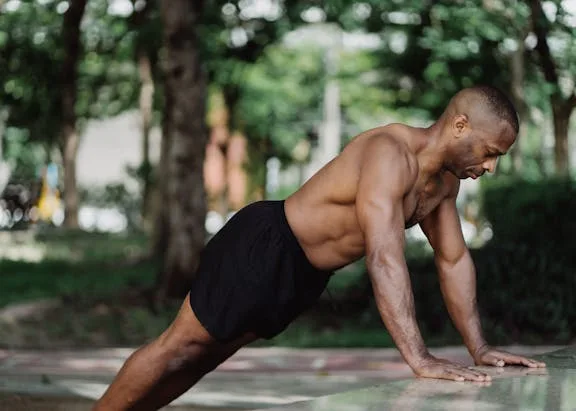man in park performing incline pushups demonstrating a part of calisthenics plan for beginners
