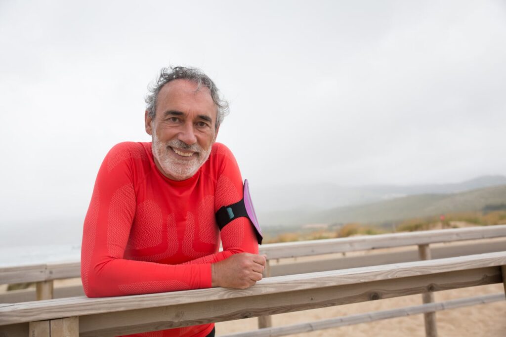 Unlock Strength and Longevity with These 5 Senior Fitness Workouts 6 happy senior man smiling as if he just had a good hike on the trail that he is standing beside