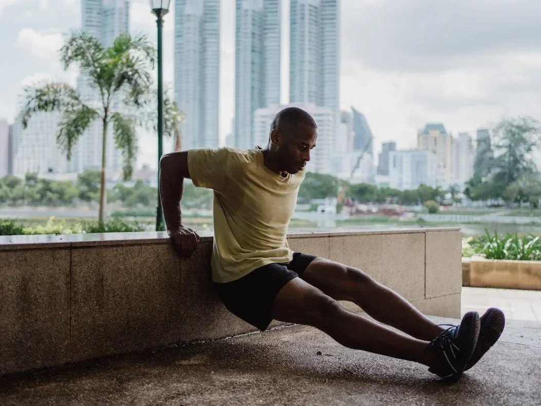 10 Simple Home Workouts for Beginners to Boost Fitness and Strength! 9 man with city backdrop doing bench dips