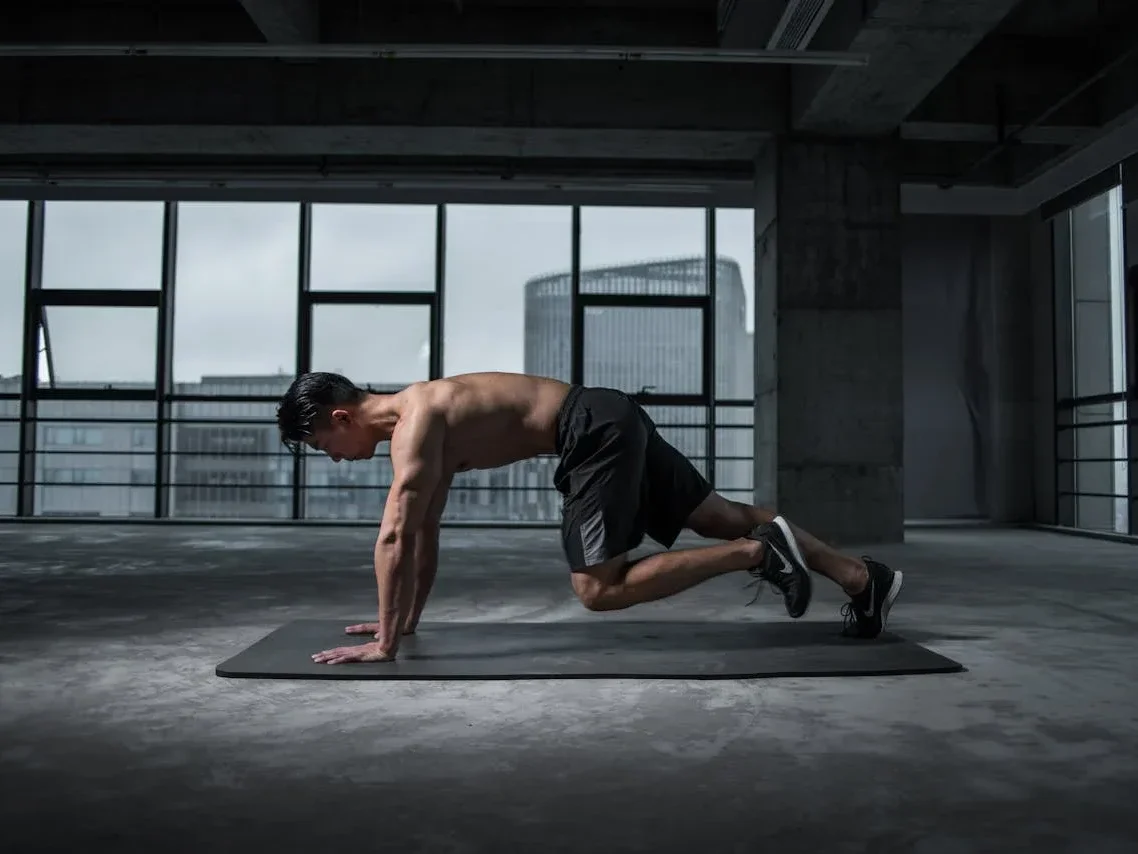 10 Simple Home Workouts for Beginners to Boost Fitness and Strength! 11 man doing mountain climbers in a city studio apartment
