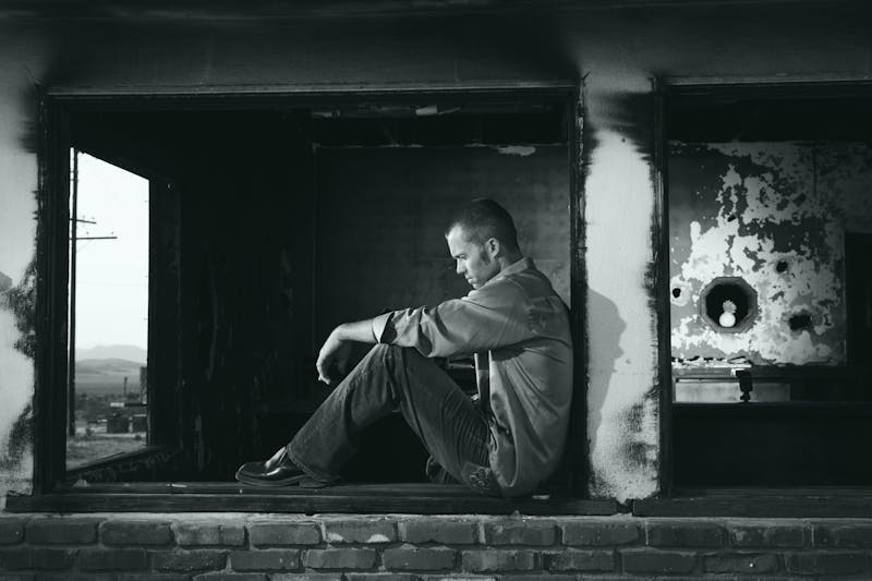 The Psychology Behind Weight Loss: 10 Powerful Mindset Shifts for Lasting Results 6 black and white image of man sitting, thinking.
