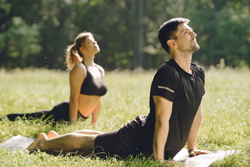 The Psychology Behind Weight Loss: 10 Powerful Mindset Shifts for Lasting Results 3 image of an athletic couple doing yoga in a grassy area
