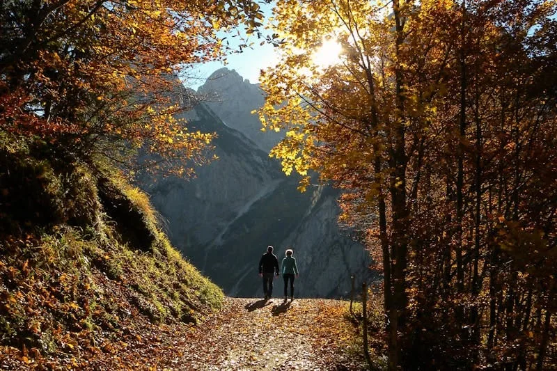 image of a fit couple walking down a mountain path with striking scenery