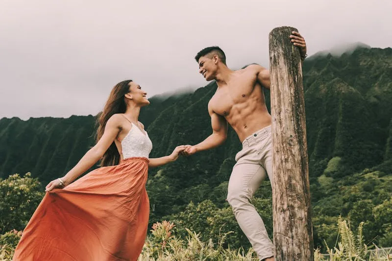 lean muscular man and woman posing outside in the country