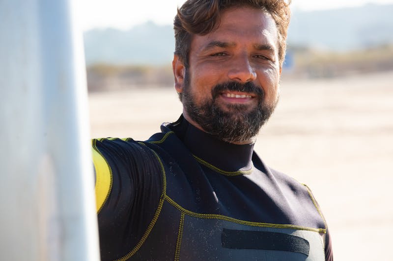 How to Get Motivated to Workout When Depressed: 5 Powerful Strategies 4 image of a man on beach smiling with his surf board