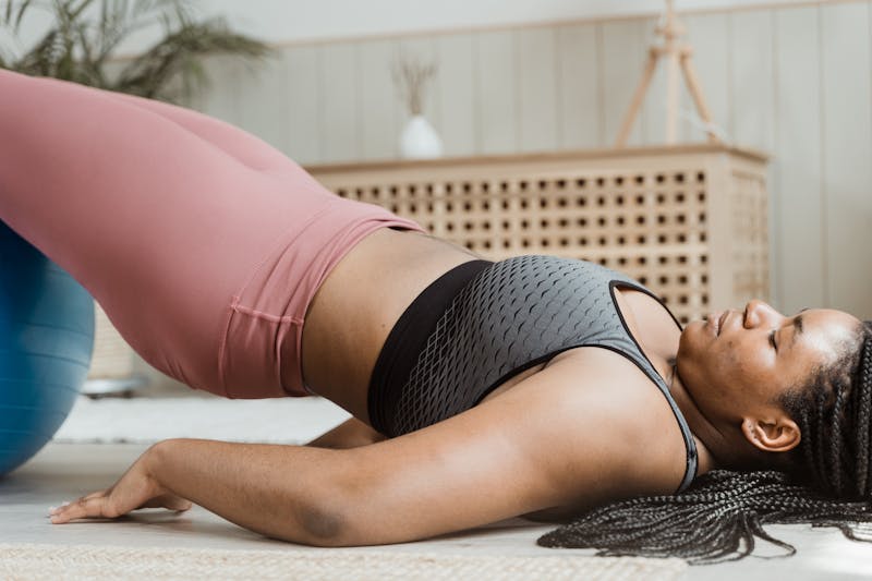 Unlock Calisthenics Strength: 3 Calisthenics Routines 6 woman performing a glute bridge using an exercise ball