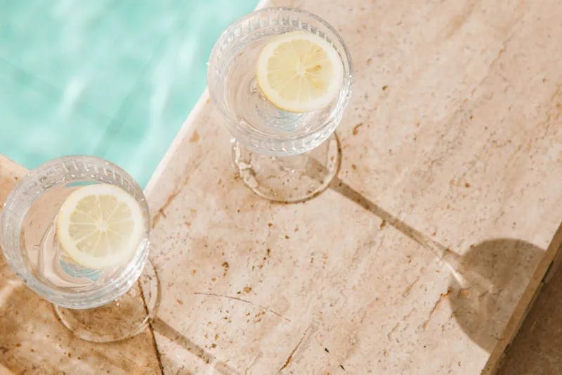 image of two glasses with water and lemon poolside