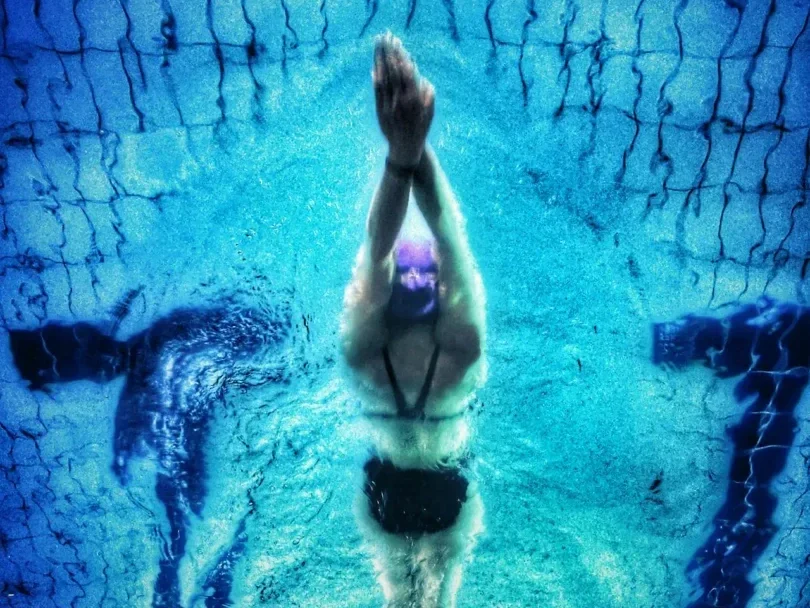 Safe Workout Tips for Those with Chronic Pain: 7 Empowering Strategies to Start Today 4 woman swimming with perfect form in a clear pool