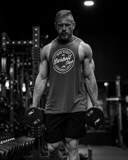 Farmer Strength Training: 6 Powerful Moves for Total Body Strength 2 man doing the farmer carry with dumbbells demonstrating farmer strength training