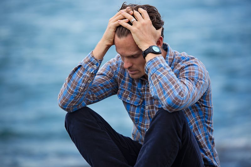 Can Lack of Sleep Make You Gain Weight? 6 Shocking Truths About Sleep and Your Waistline 4 man seated, holding head in hands