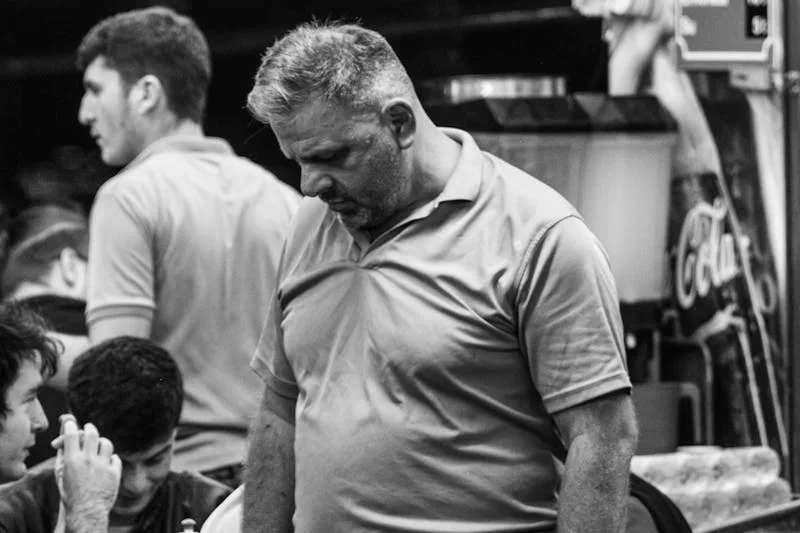 black and white image of a depressed overweight man