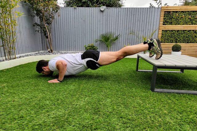 7 Powerful Functional Fitness Moves for Tough Times 2 man performing decline pushups with feet elevated