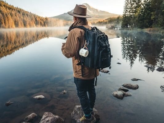 Survival Fitness: Master Your Life and Thrive when SHTF 7 man prepared for survival with backpack standing next to a mountain lake
