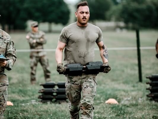 Survival Fitness: 6 Surprising Reasons You’re Not as Fit as You Think 5 soldier carrying heavy weights to build survival fitness
