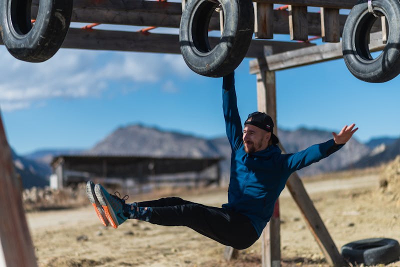 Functional Strength Through Calisthenics: Unlocking Your Full Potential 8 man performing a one-arm hang