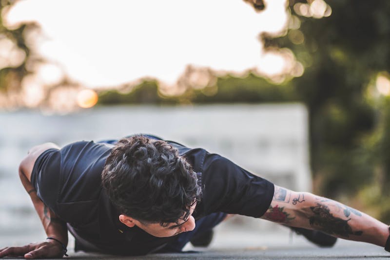 Functional Strength Through Calisthenics: Unlocking Your Full Potential 3 man performing archer pushups