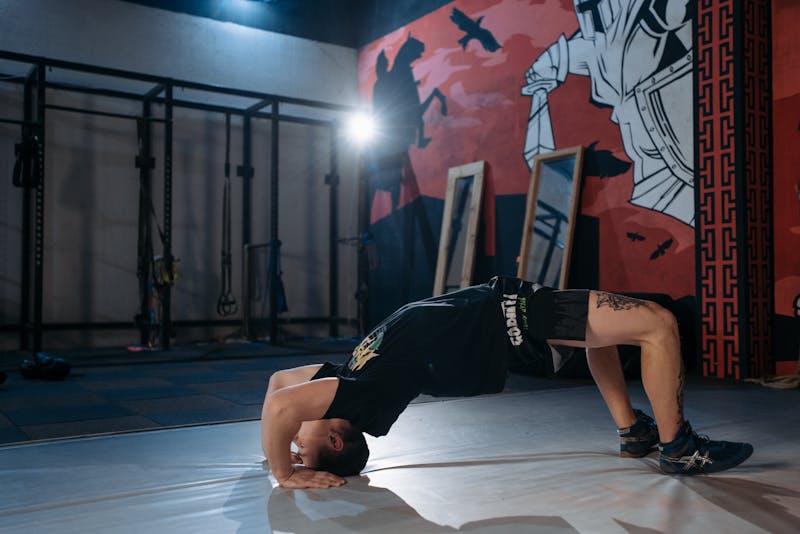 Functional Strength Through Calisthenics: Unlocking Your Full Potential 2 man doing neck bridge functional strength exercise