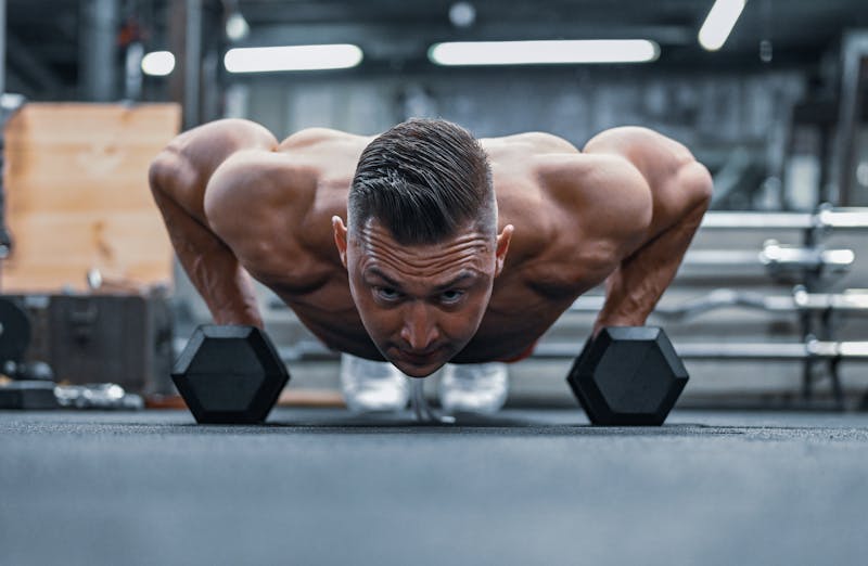 Bodyweight Workout for Weight Loss: 5 Powerful Routines to Burn Fat Fast 2 man doing push ups on dumbbells demonstrating bodyweight workout for weight loss