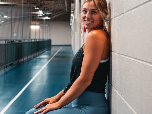 10 Powerful Exercises: Calisthenics for Beginners at Home 3 smiling woman doing a wall-sit