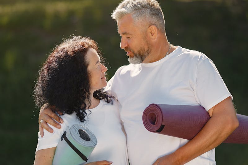 Strength Training for Seniors: 7 Powerful Ways to Stay Strong and Independent for Life 2 a man and woman holding yoga mats in a park after workout